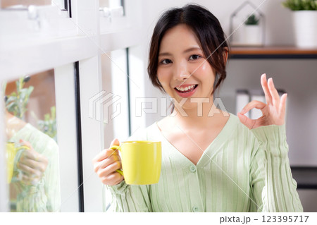 Portrait young asian woman relax and enjoyment with drinking coffee by the window in living room. 123395717