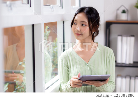 Portrait young asian business woman using tablet computer for relax and check social media online. 123395890