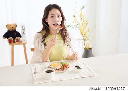 ダイニングで朝ごはんを食べる女性 123395957