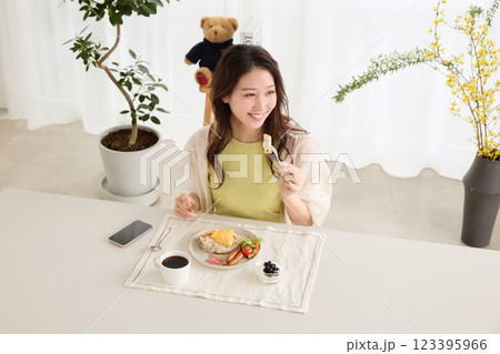 ダイニングで朝ごはんを食べる女性 123395966