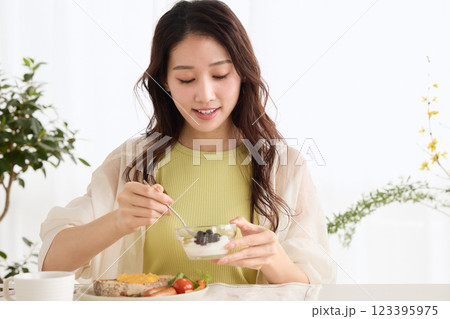 ダイニングで朝ごはんを食べる女性 123395975