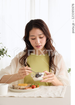 ダイニングで朝ごはんを食べる女性 123395976