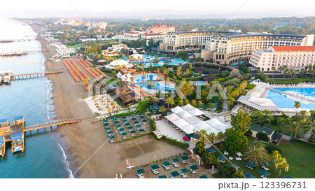 Aerial view of a luxury beachfront resort with pools, private piers, and lush tropical landscapes Aerial view of a luxury beachfront resort with pools, private piers, and lush tropical landscapes 123396731