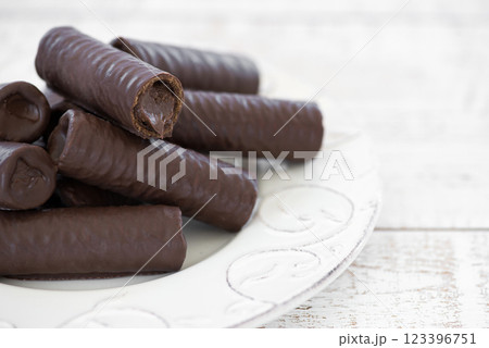 Sweet chocolate covered rolls - table arrangement, isolated on white background. Selective focus. Copy space. 123396751