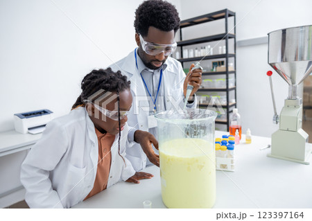 Male teacher and a school girl working on chemistry experiment in a school lab Male teacher and a school girl working on chemistry experiment in a school lab 123397164
