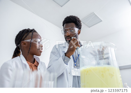 Teacher and student working in a school laboratory and looking involved Teacher and student working in a school laboratory and looking involved 123397175