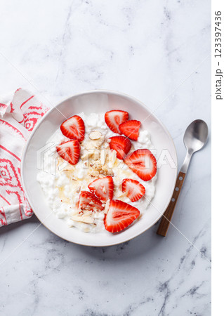 Breakfast: cottage cheese with honey, strawberry and nuts. 123397436