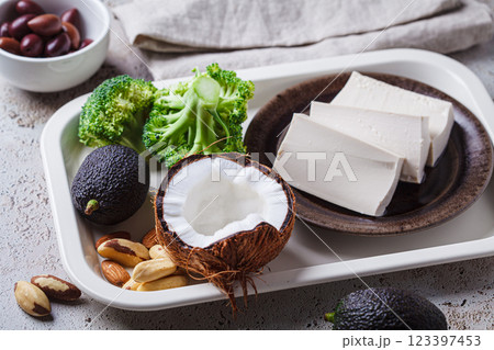 Vegan ingredients for keto diet: tofu, avocado, nuts, broccoli, coconut and olives. Vegan ingredients for keto diet: tofu, avocado, nuts, broccoli, coconut and olives. 123397453