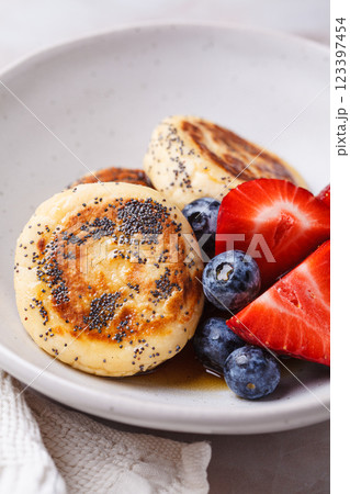 Cottage cheese pancakes with poppy seeds, syrup and berries. Cottage cheese pancakes with poppy seeds, syrup and berries. 123397454
