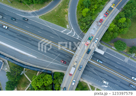 Vehicles travel through complex highway interchange surrounded by greenery near American town at New Jersey Vehicles travel through complex highway interchange surrounded by greenery near American town at New Jersey 123397579