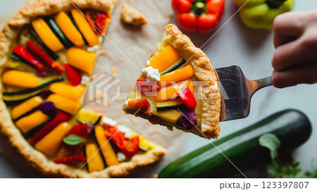 zucchini pie with sweet peppers and feta cheese, slice lifted with spatula, golden flaky crust, vibrant vegetable filling, cheese stretch, scattered crumbs, rustic aesthetic, natural textures, festive zucchini pie with sweet peppers and feta cheese, slice lifted with spatula, golden flaky crust, vibrant vegetable filling, cheese stretch, scattered crumbs, rustic aesthetic, natural textures, festive 123397807