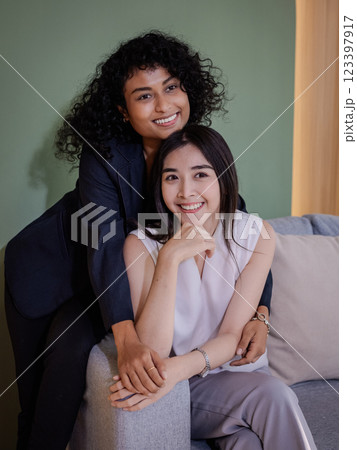 Smiling lgbtq Women Friends Embracing on Couch, Enjoying Casual Lifest 123397917