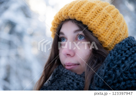 Happy smiling young woman in scarf and hat enjoying winter weather in snowy winter park 123397947