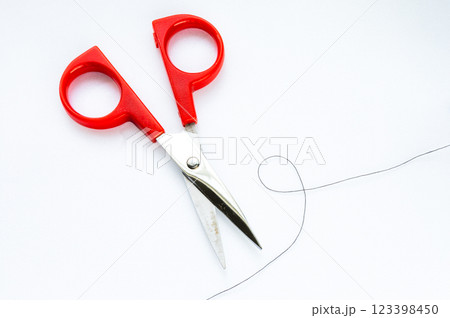 白の背景にハサミで糸を切るイメージ 白の背景にハサミで糸を切るイメージ 123398450