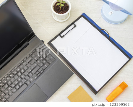 Shot of the plastic folder on the office desk with paper clip holder on the top and other office items. A4 size paper mock up. 123399562