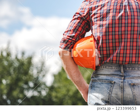 Attractive man in work clothes with a protective helmet Attractive man in work clothes with a protective helmet 123399653