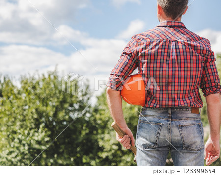 Attractive man in work clothes with a protective helmet Attractive man in work clothes with a protective helmet 123399654