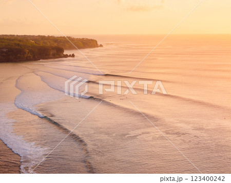 Scenic landscape with warm sunset tones and ocean with surfing wave in Bali. 123400242