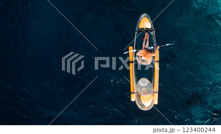 Woman float on transparent kayak in blue sea. Drone view, top down 123400244