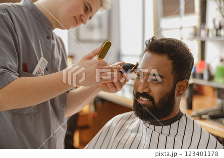 A Skilled Barber Providing Exceptional Haircut and Grooming Services at a Modern Salon A Skilled Barber Providing Exceptional Haircut and Grooming Services at a Modern Salon 123401178