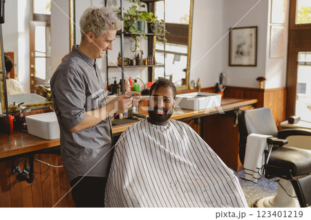 A barber cuts hair in a modern barbershop, blending contemporary culture with grooming 123401219