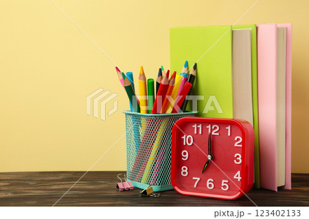Red alarm clock and school accessories on a beige background. Back to school concept. 123402133