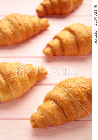 Freshly baked croissants on pink wooden background Warm Fresh Buttery Croissants and Rolls. French and American Croissants and Baked Pastries 123402146