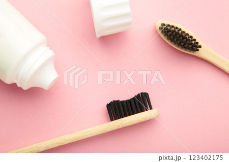 Bamboo toothbrush with toothpaste on pink background. 123402175