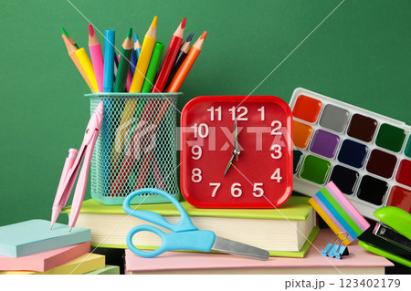 Red alarm clock and school accessories on a green background. Back to school concept. 123402179