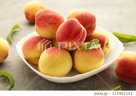 Plate of ripe peaches on grey background. 123402181