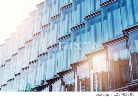 View of modern glass metal high rise building facade with sun reflection flare at sunset evening time in Berlin Mitte city urban street.  Business financial corporate office futuristic architecture 123402506