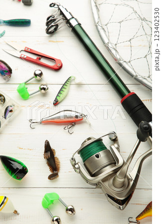 Nikolaev, Ukraine - 08 july, 2022: Fishing rods and spinnings in the composition with accessories for fishing on white background. Nikolaev, Ukraine - 08 july, 2022: Fishing rods and spinnings in the composition with accessories for fishing on white background. 123402530
