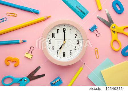Alarm clock, paint, pencils and scissors. School accessories on a pink background. Back to school concept. 123402534