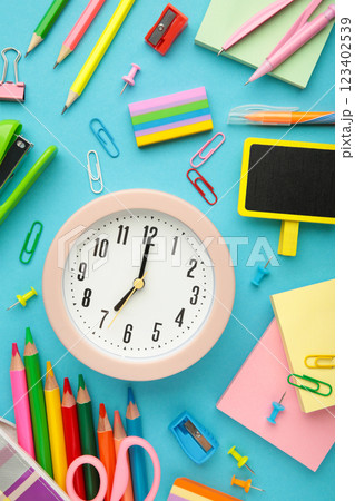 Alarm clock, paint, pencils and scissors. School accessories on a blue background. Back to school concept. 123402539