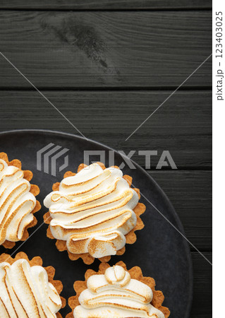 Appetizing lemon cupcakes with white cream on dark background. Holiday, surprise, birthday, Valentine's Day. Vertical photo Appetizing lemon cupcakes with white cream on dark background. Holiday, surprise, birthday, Valentine's Day. Vertical photo 123403025