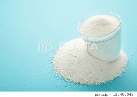 Washing powder in a measuring cup on a blue background Washing powder in a measuring cup on a blue background 123403042