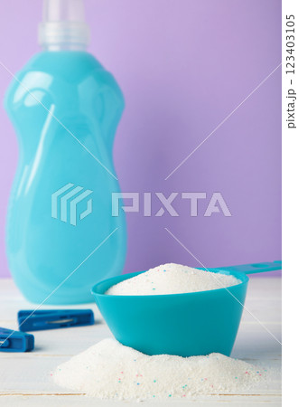 Laundry detergents with washing powder on purple background. Vertical photo 123403105