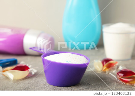 Laundry detergents with washing powder and capsules on grey background 123403122