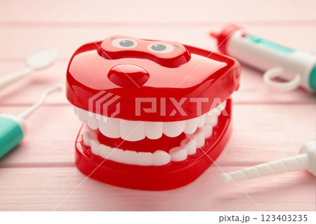 Model toys teeth with dentist instrument on pink background. Model toys teeth with dentist instrument on pink background. 123403235