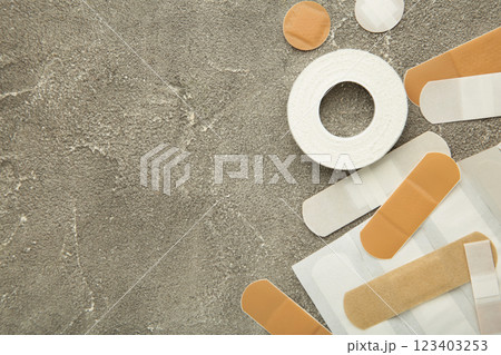Beige adhesive bandages on grey background. Medical plasters 123403253