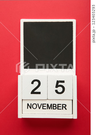 Wooden calendar 2022 with inscription 25 november on red background. Black friday. Vertical photo 123403293