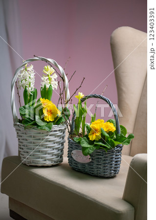 This charming flower basket showcases beautiful yellow blooms along with vibrant greenery 123403391