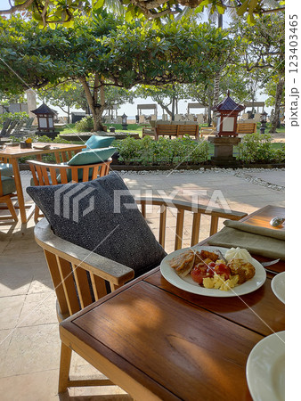 Breakfast table at Asian resort. Pancakes, sandwiches, coffee, juices, salad, fresh fruits. Healthy, delicious dishes on a sunny Bali vacation. 123403465