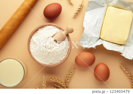 Ingredients for baking or cooking, egg flour, rolling pin butter, milk on a beige background Cookie pie or cake recipe. Ingredients for baking or cooking, egg flour, rolling pin butter, milk on a beige background Cookie pie or cake recipe. 123403479