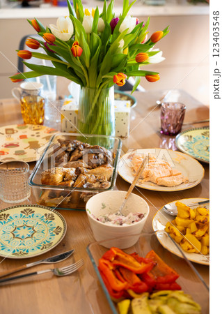 A beautifully set dining table with a vibrant tulip bouquet as a centerpiece. 123403548