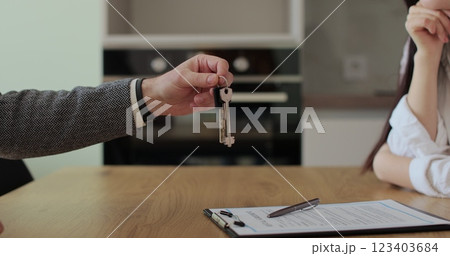 Realtor gives keys to the couple who buys a new house. Real estate, property purchase, mortgage concept. 123403684