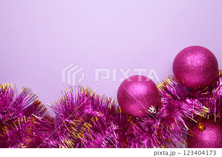 Pink Christmas ball decorations with tinsel on purple background. 123404173