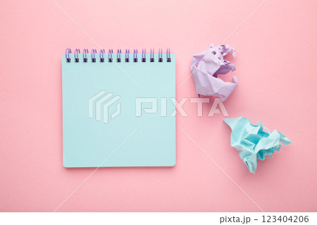 Blank paper notebook and damaged sheets on pink background. Office desk table concept. Blank paper notebook and damaged sheets on pink background. Office desk table concept. 123404206