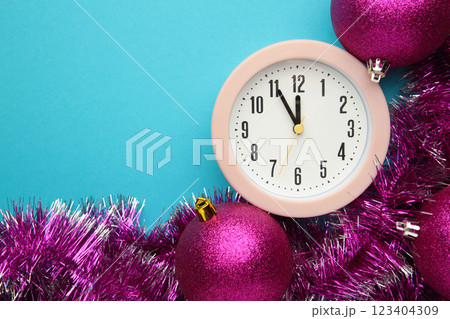 New Year's clock decorated with christmas tinsel and ball. Celebration Concept for New Year Eve. New Year's clock decorated with christmas tinsel and ball. Celebration Concept for New Year Eve. 123404309