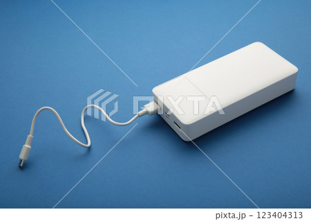 Portable powerbank with usb cable on blue background. 123404313